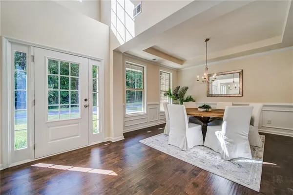 a dining room with furniture a chandelier and wooden floor
