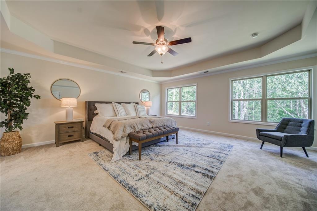 3430 South Scales Road Duluth, GA 30097 - Photo 53 of 77 a spacious bedroom with a bed a couch and a window