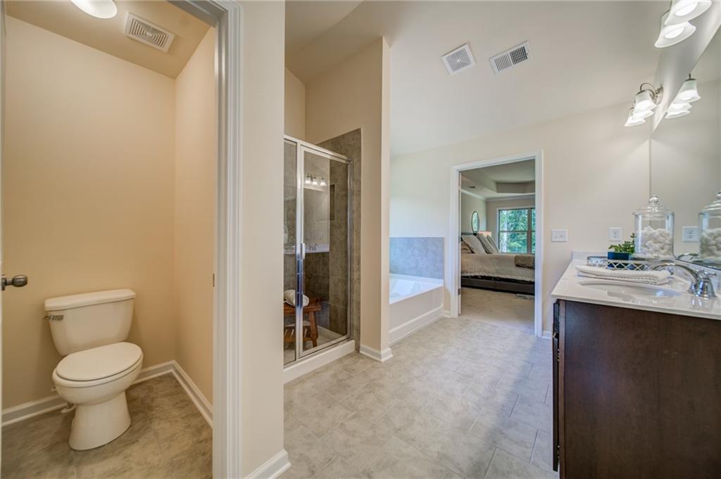 3430 South Scales Road Duluth, GA 30097 - Photo 61 of 77 a bathroom with a toilet a sink and mirror