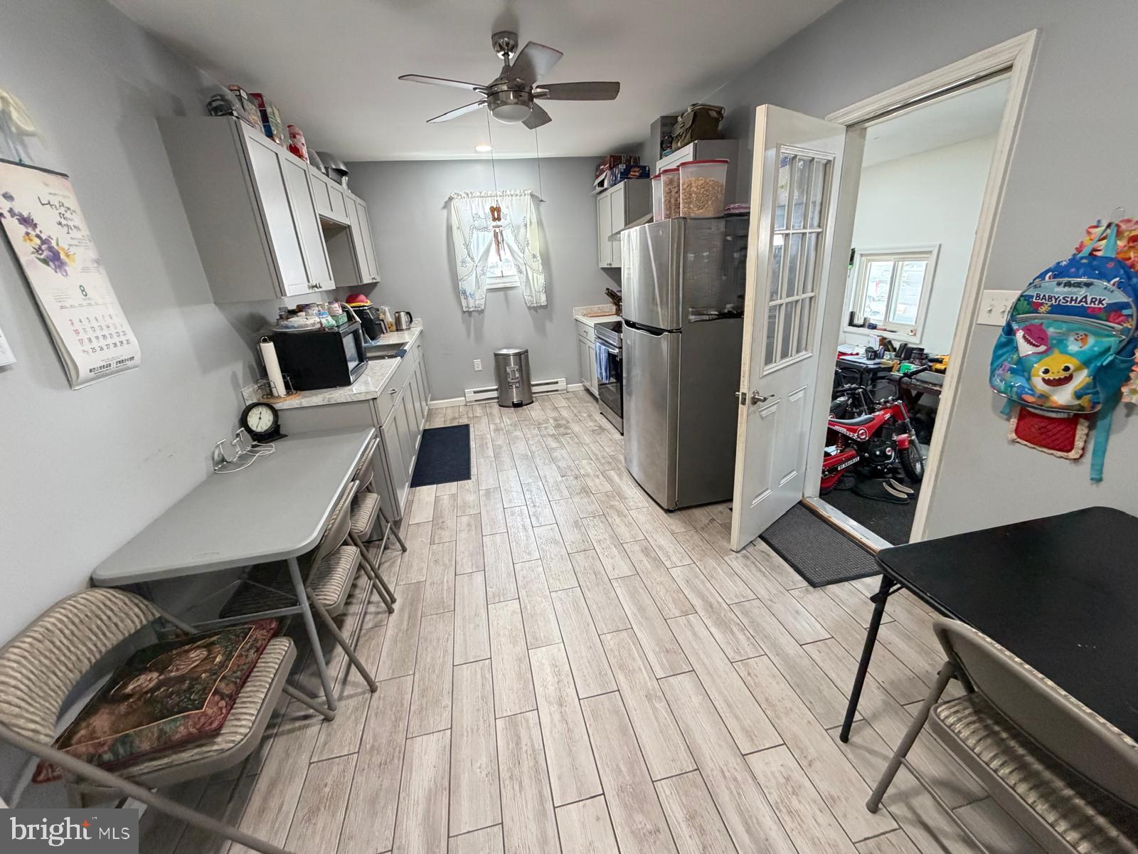 823 West Main Street Waynesboro, PA 17268 - Photo 6 of 24 a kitchen with stainless steel appliances a refrigerator a sink dishwasher a stove a dining table and chairs with wooden floor