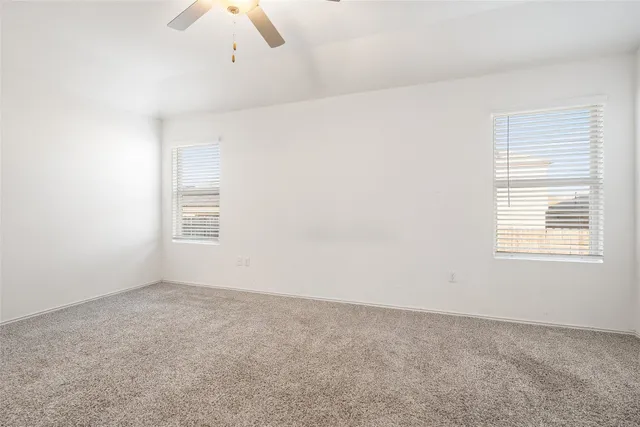 a view of a big room with wooden floor a ceiling fan window and a ceiling fan