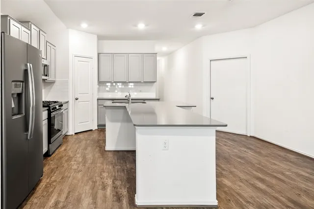 a kitchen with stainless steel appliances granite countertop a refrigerator and a stove