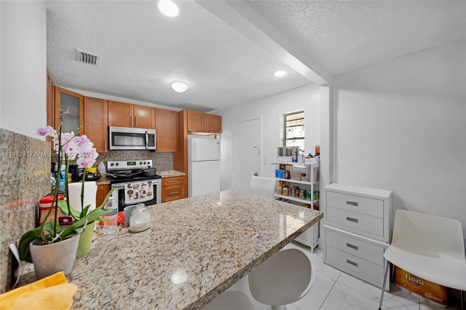 1137 Northwest 2nd Street Miami, FL 33128 - Photo 12 of 32 a kitchen with stainless steel appliances granite countertop a sink refrigerator and microwave
