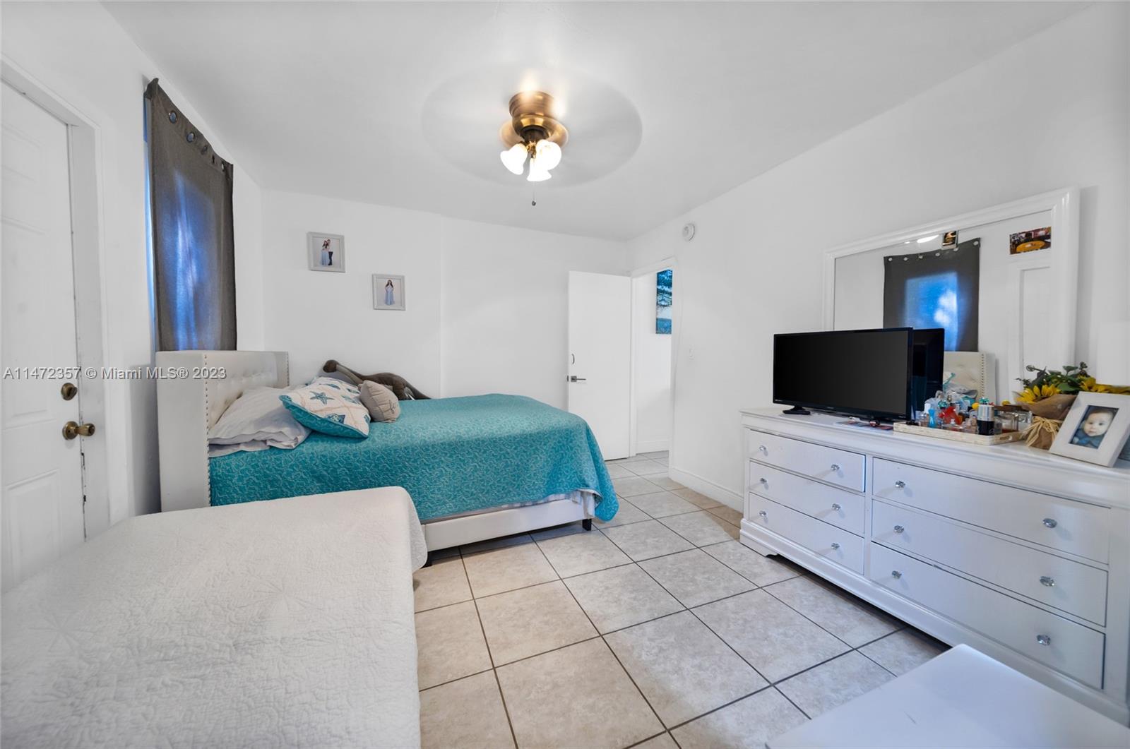 1137 Northwest 2nd Street Miami, FL 33128 - Photo 24 of 32 a bedroom with a bed and a chandelier