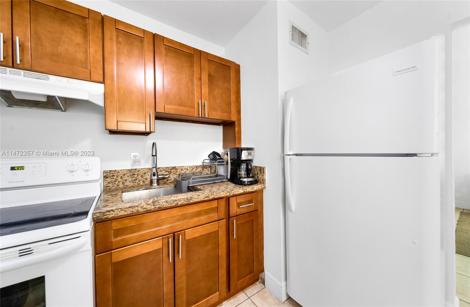 1137 Northwest 2nd Street Miami, FL 33128 - Photo 30 of 32 a kitchen with stainless steel appliances granite countertop a sink stove and refrigerator
