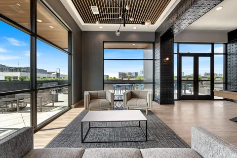 a living room with furniture and a floor to ceiling window