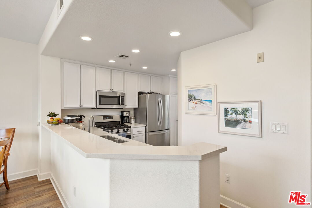 12963 West Runway Road, Unit 408 Playa Vista, CA 90094 - Photo 13 of 44 a kitchen with stainless steel appliances a refrigerator and a stove top oven
