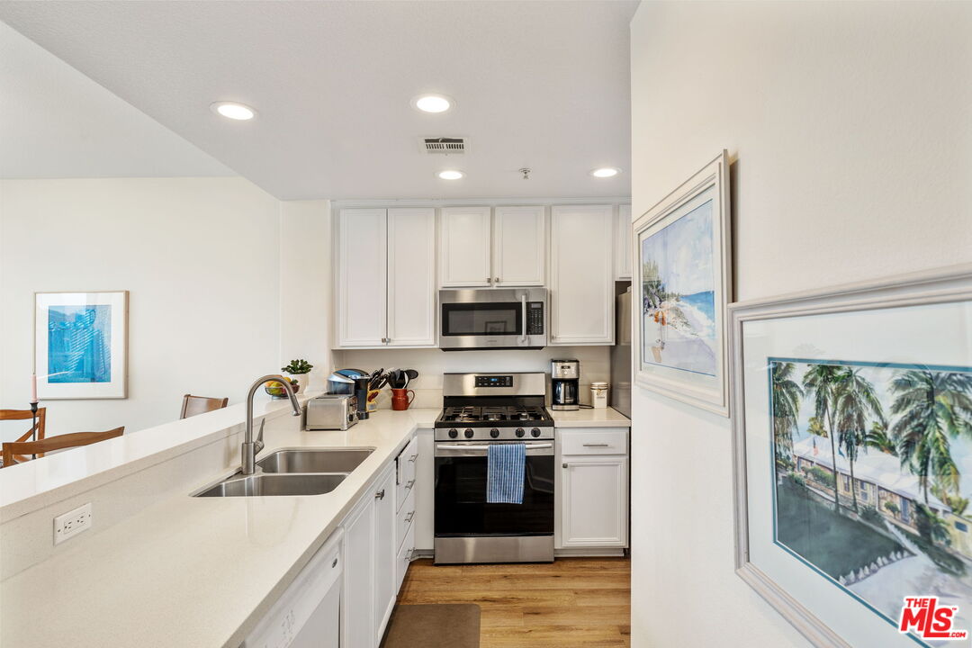 12963 West Runway Road, Unit 408 Playa Vista, CA 90094 - Photo 14 of 44 a kitchen with stainless steel appliances a sink a stove a refrigerator cabinets and a window