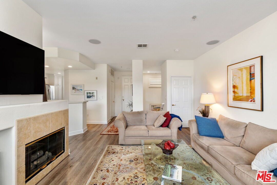 12963 West Runway Road, Unit 408 Playa Vista, CA 90094 - Photo 8 of 44 a living room with furniture a flat screen tv and a fireplace