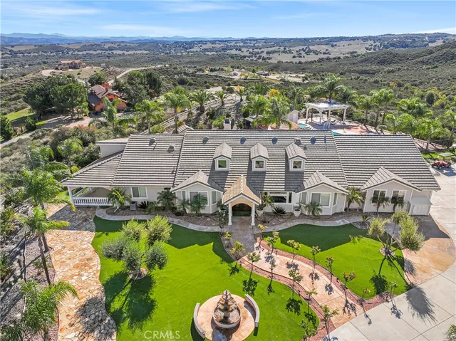an aerial view of a house with garden space and ocean view