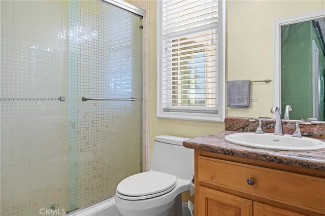 an empty room with chandelier fan and windows