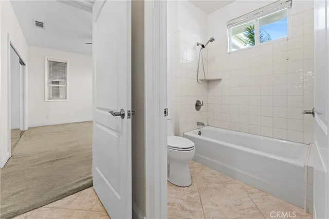 a view of an empty room with closet and wooden door