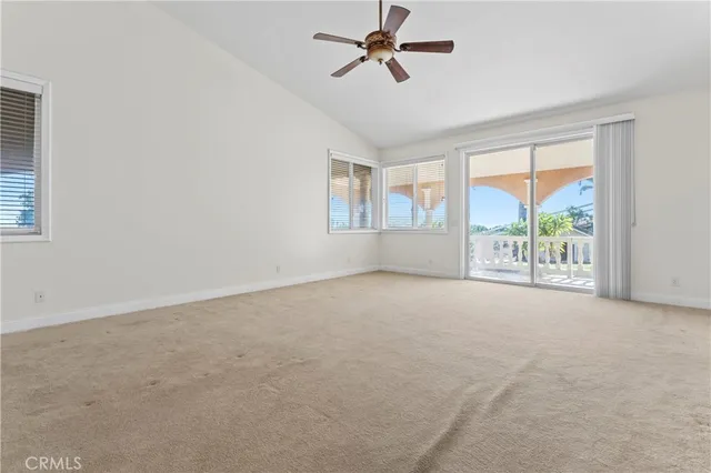 an empty room with a ceiling fan and a window