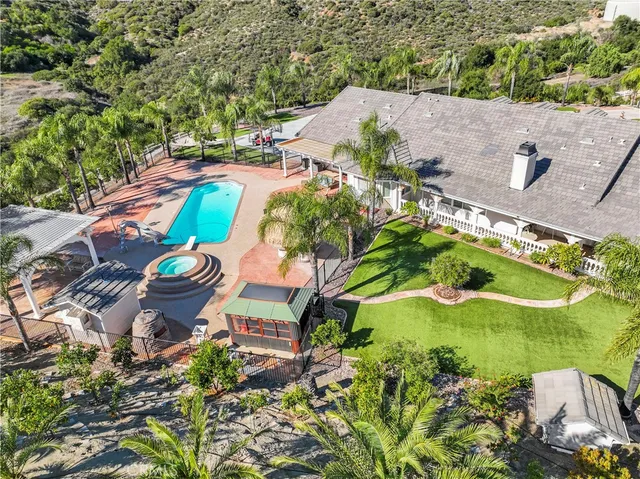 an aerial view of a house with a garden and lake view