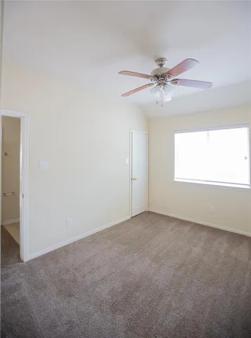 an empty room with windows and fan