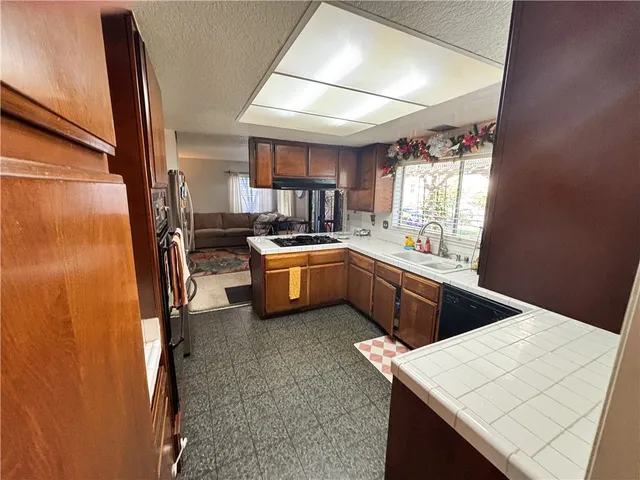 a kitchen with stainless steel appliances a sink window and cabinets