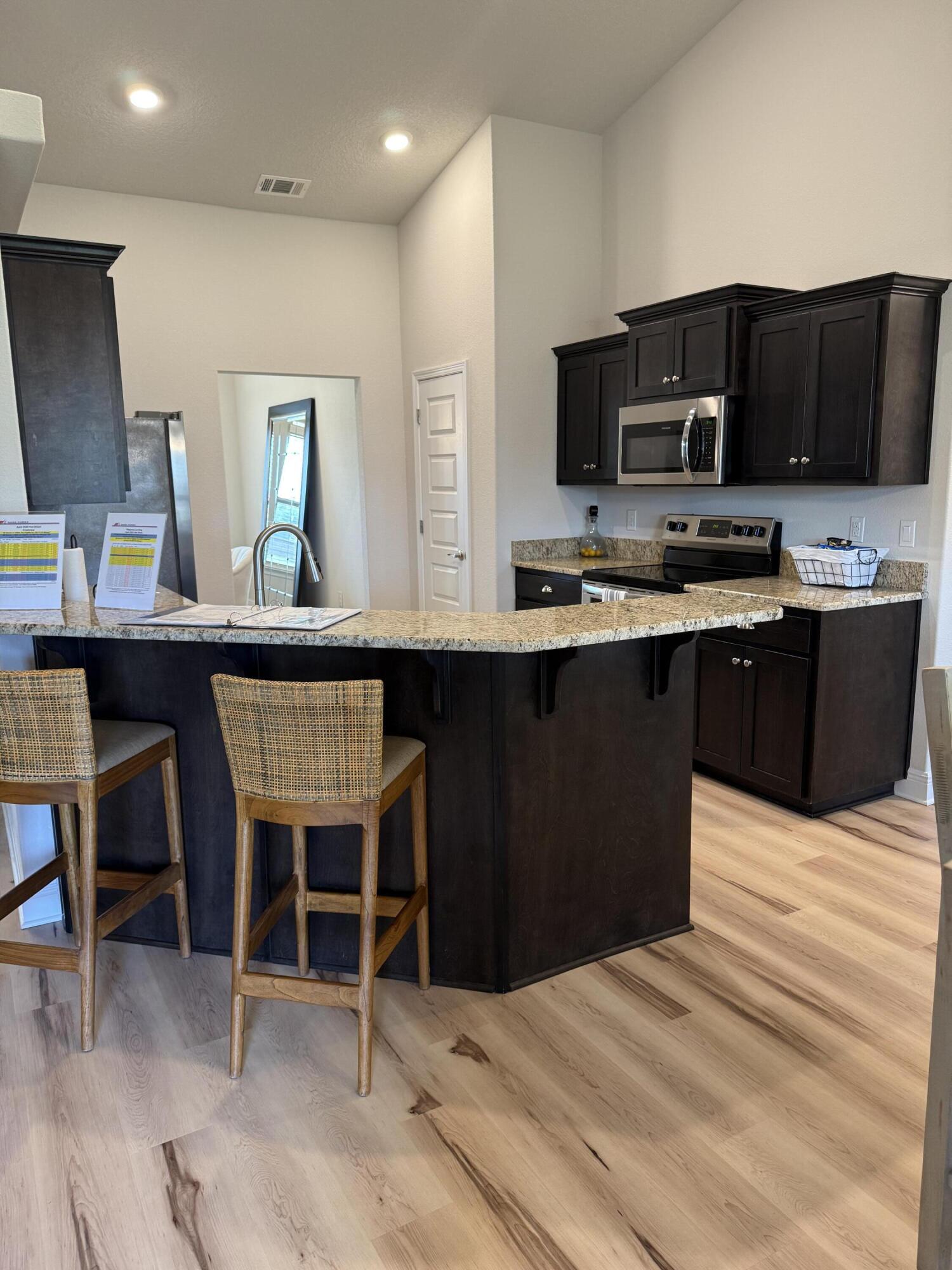 5825 Crestlake Drive Crestview, FL 32536 - Photo 17 of 29 a kitchen with stainless steel appliances kitchen island granite countertop a sink and a microwave