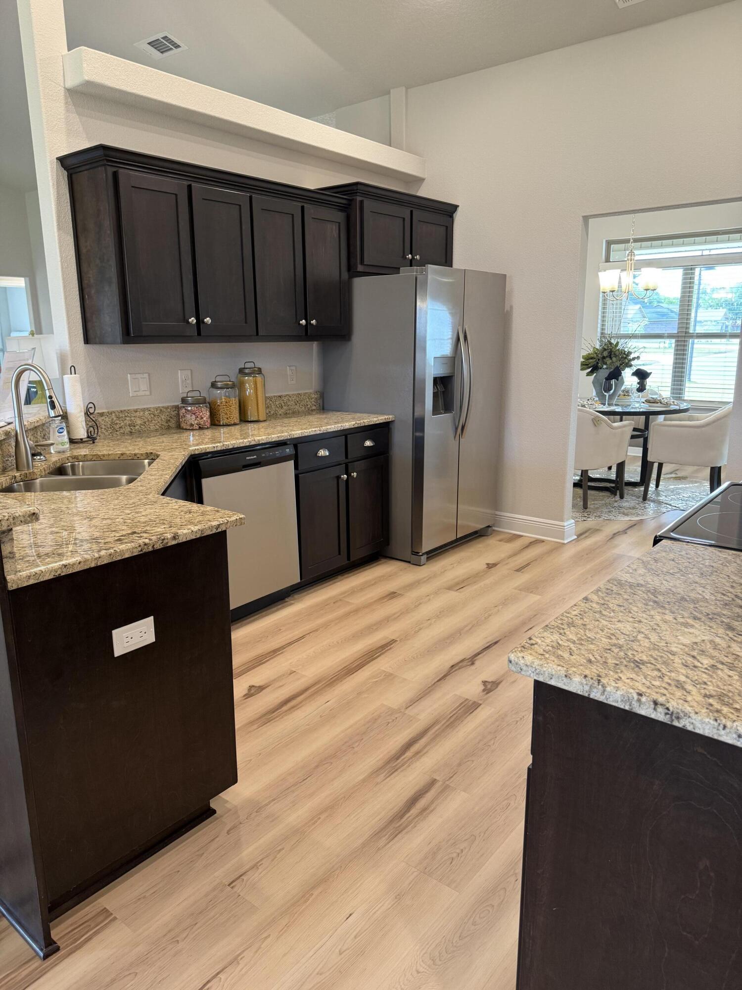 5825 Crestlake Drive Crestview, FL 32536 - Photo 18 of 29 a kitchen with stainless steel appliances granite countertop a sink stove and microwave