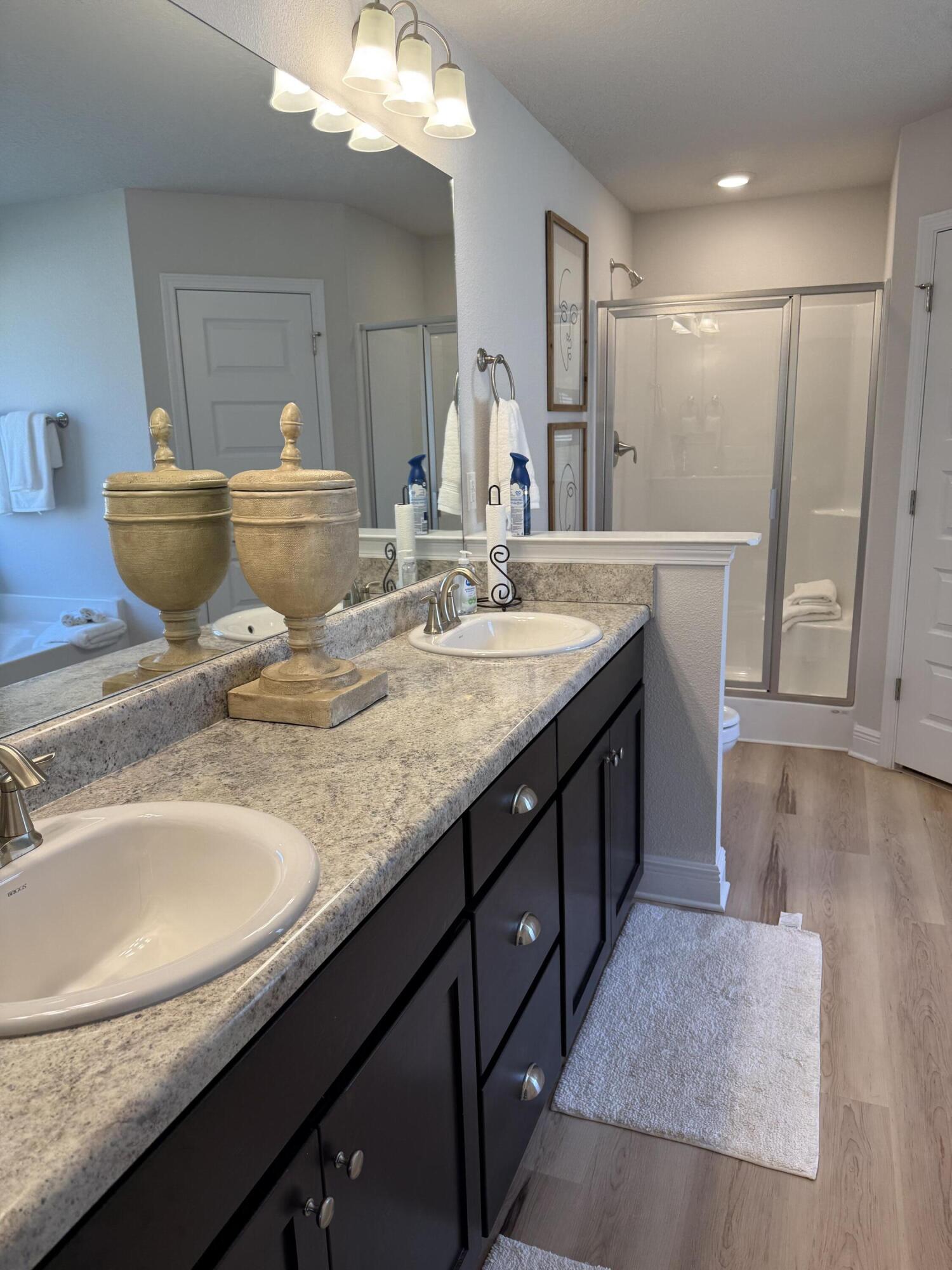 5825 Crestlake Drive Crestview, FL 32536 - Photo 23 of 29 a bathroom with a granite countertop sink a large mirror and a shower