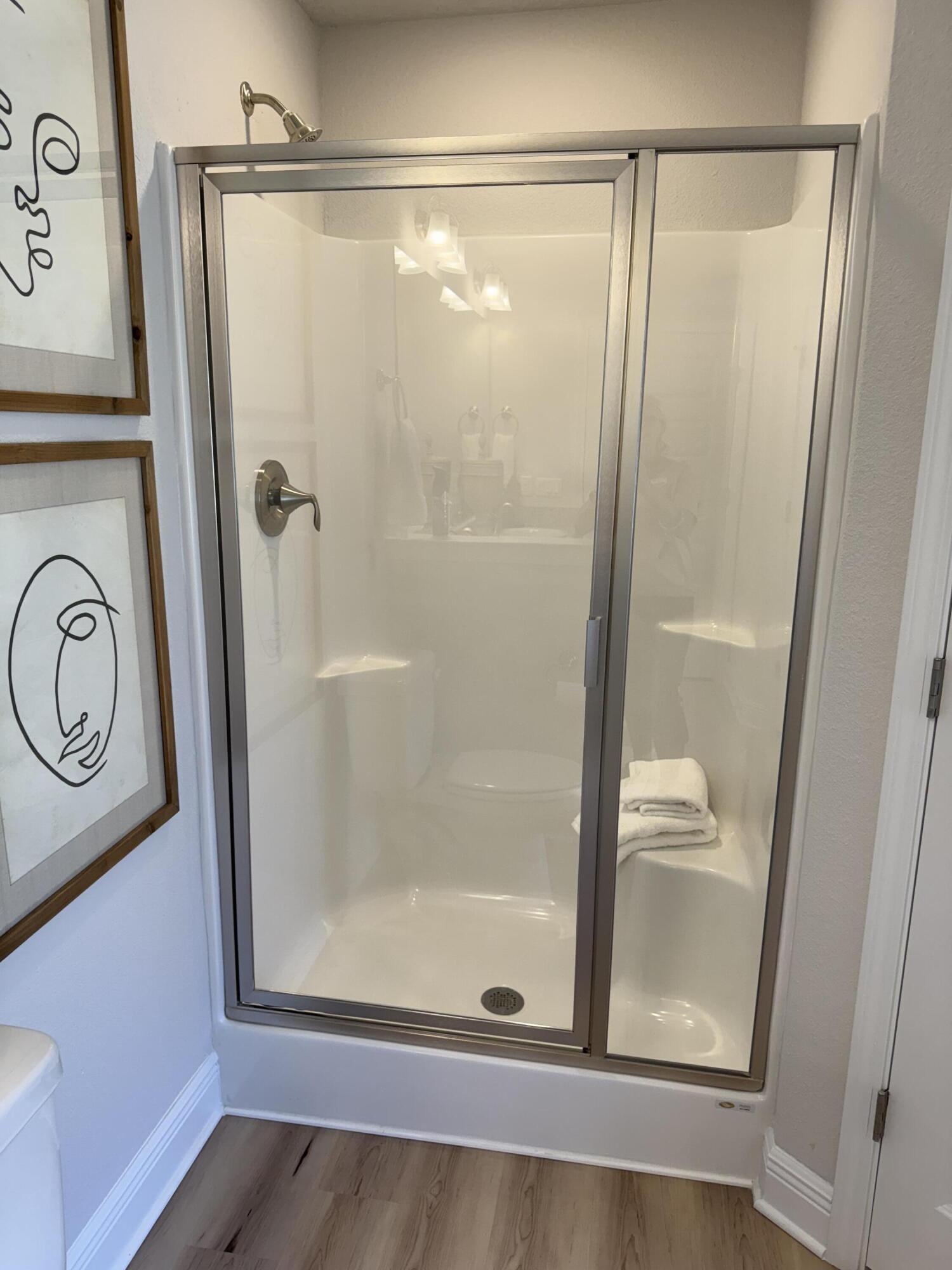 5825 Crestlake Drive Crestview, FL 32536 - Photo 25 of 29 a bathroom with a glass shower door and a window