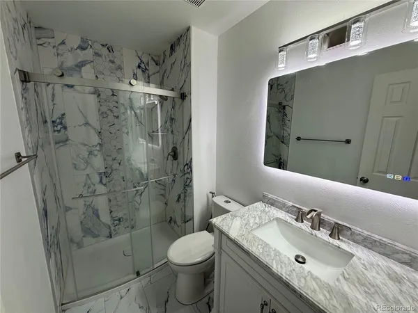 a bathroom with a sink toilet and shower