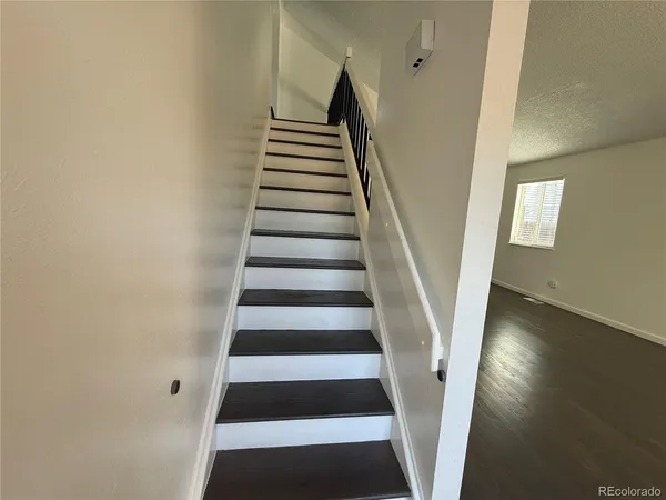 a view of a hallway with wooden floor and windows