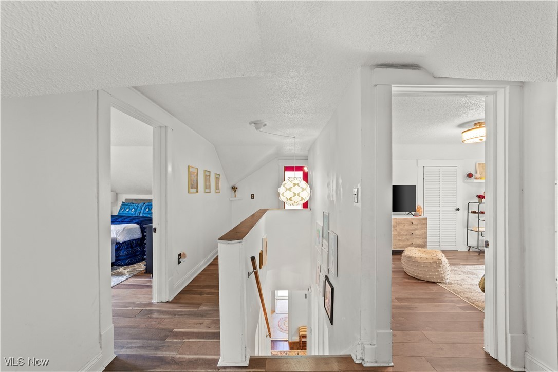 14420 Superior Road Cleveland, OH 44118 - Photo 26 of 44 Stairway featuring a textured ceiling, wood finished floors, and baseboards
