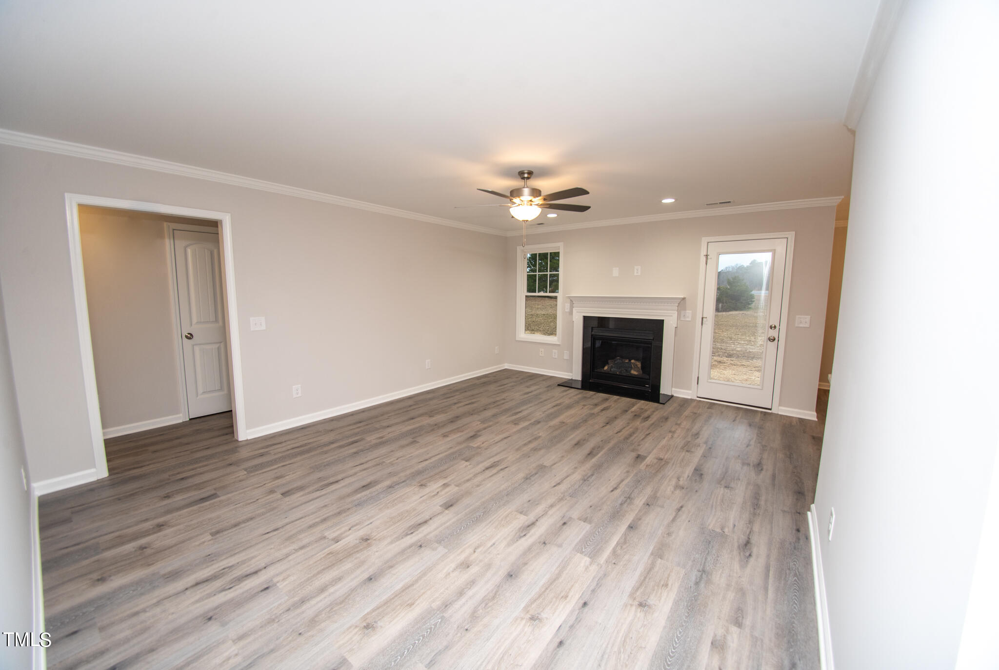 243 Waters Edge Drive Erwin, NC 28339 - Photo 5 of 53 an empty room with wooden floor fireplace and a window