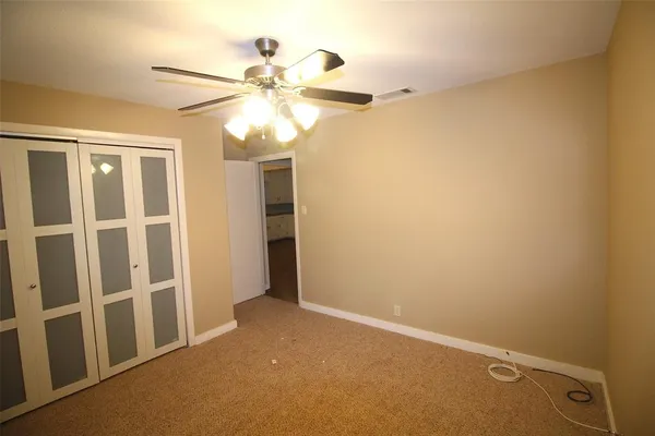 an empty room with a window and a fan