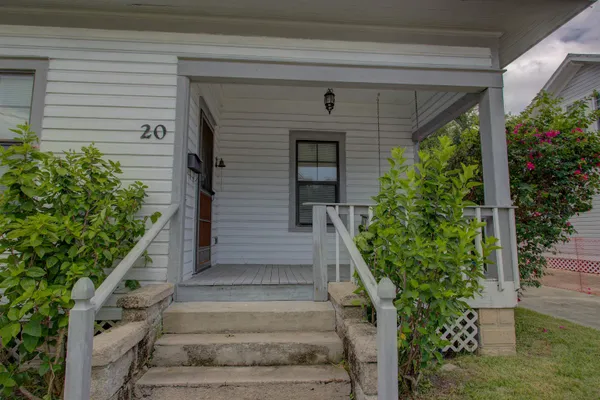 a front view of a house with plants