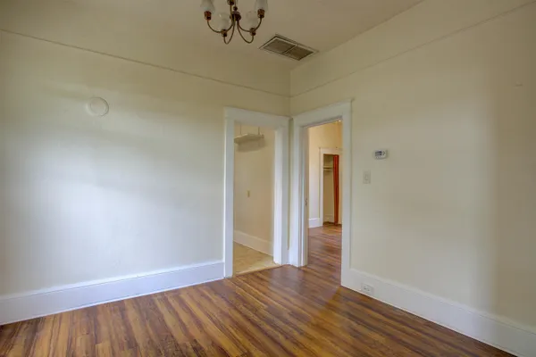 a view of an empty room with wooden floor