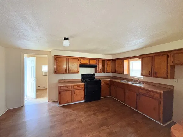 a kitchen with granite countertop a sink cabinets and stainless steel appliances
