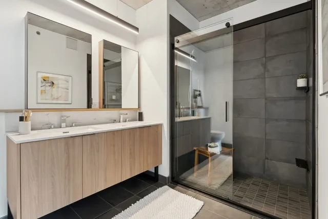 a bathroom with a double vanity sink toilet and shower