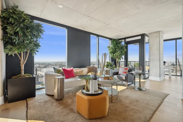 a living room with furniture a chandelier and a floor to ceiling window