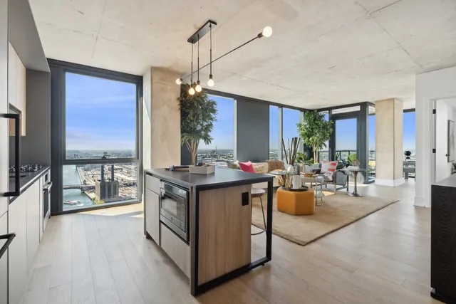 a view of living room kitchen with stainless steel appliances granite countertop cabinets and wooden floor