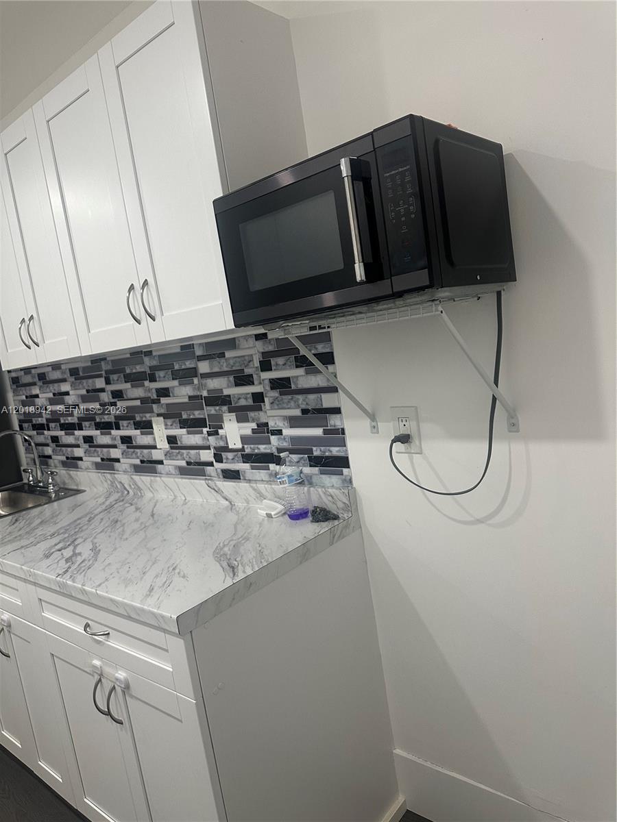 13740 Southwest 282nd Street, Unit 1 Homestead, FL 33033 - Photo 4 of 9 a kitchen with a refrigerator and a stove top oven