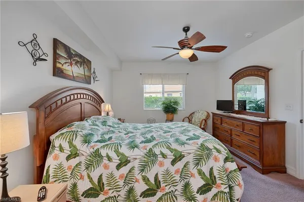 a bedroom with a bed and a dresser with mirror