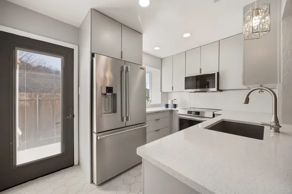 a kitchen with a refrigerator a microwave a sink and cabinets