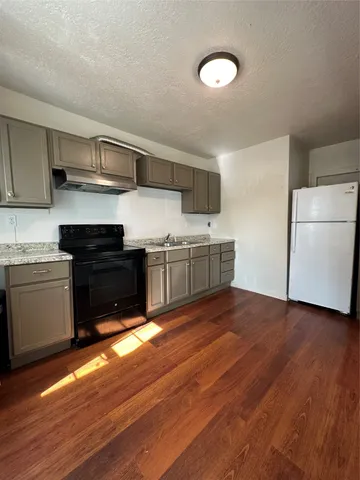 a kitchen with stainless steel appliances granite countertop a stove a sink and a refrigerator