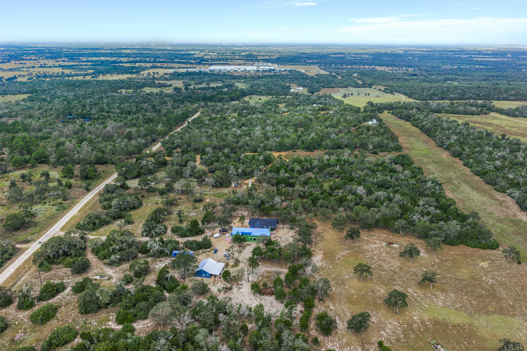3301 Chuckwagon Road Harwood, TX 78632 - Photo 25 of 36 An expansive aerial perspective captures a private homestead nestled within dense, rolling woodlands.