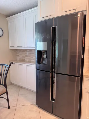 a metallic refrigerator freezer sitting in a kitchen