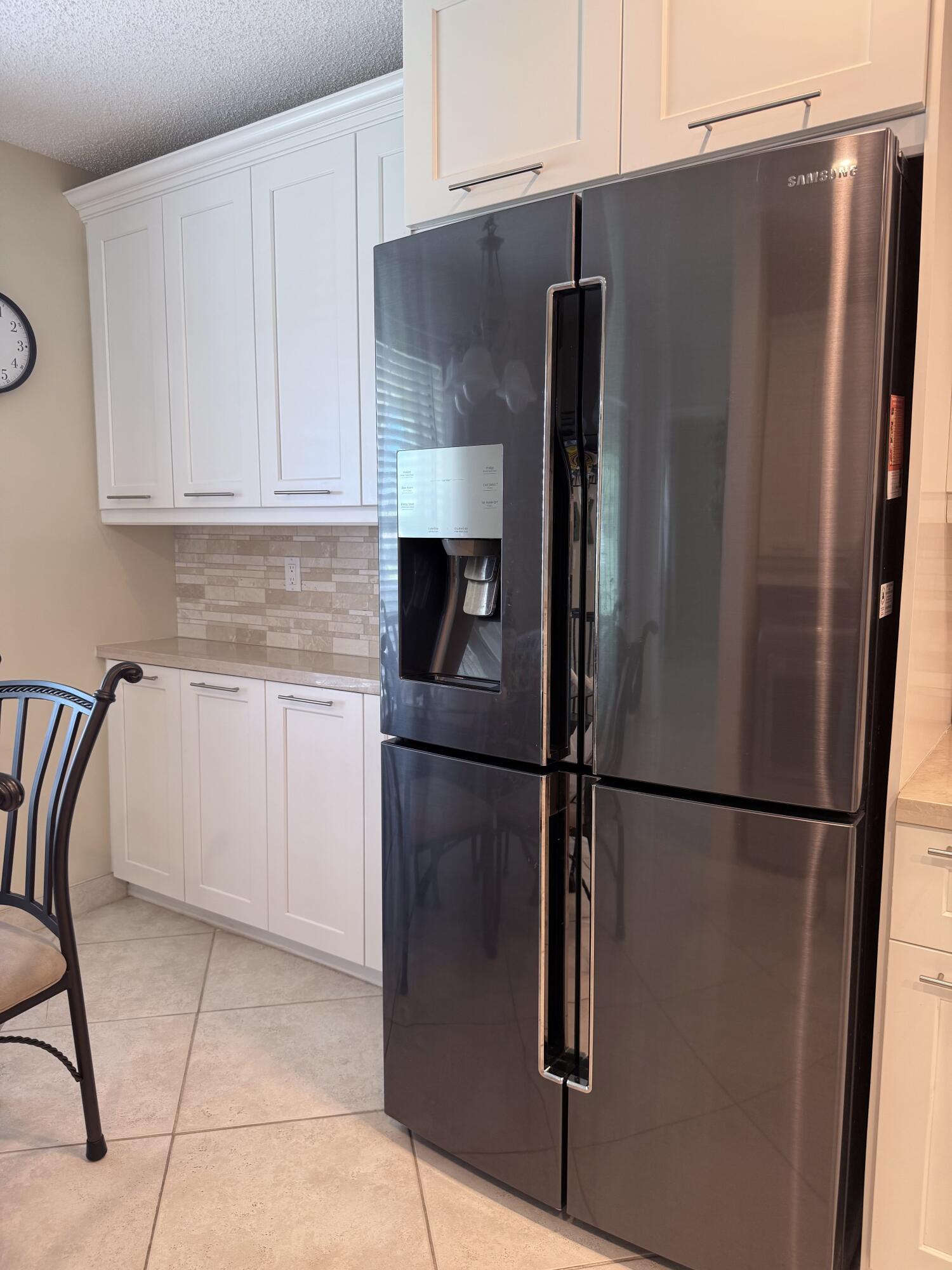 1720 Northwest 20th Avenue, Unit 204 Delray Beach, FL 33445 - Photo 11 of 30 a metallic refrigerator freezer sitting in a kitchen