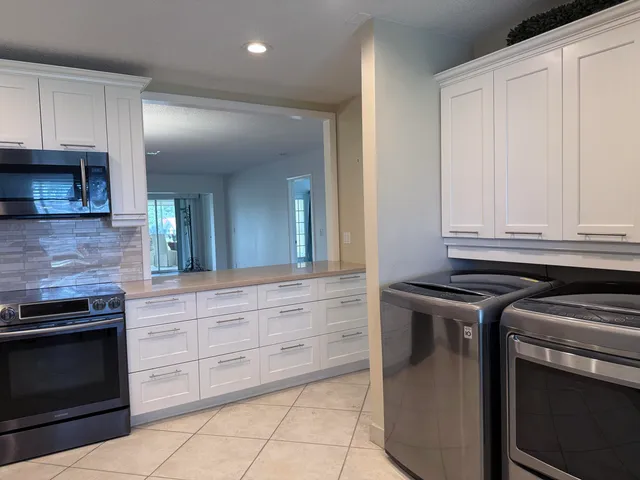 a kitchen with granite countertop white cabinets and stainless steel appliances