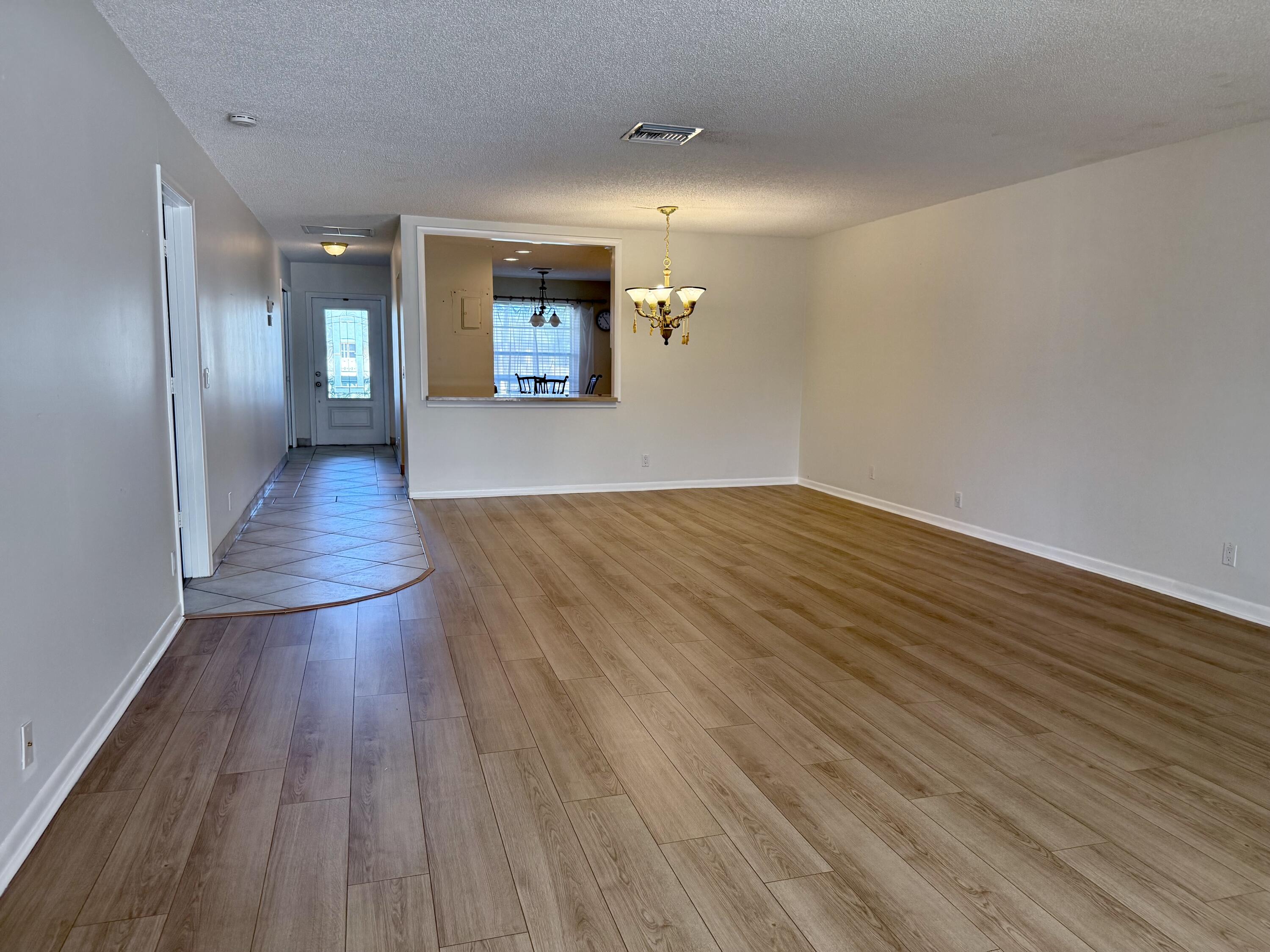 1720 Northwest 20th Avenue, Unit 204 Delray Beach, FL 33445 - Photo 15 of 30 wooden floor in a hall with an empty room