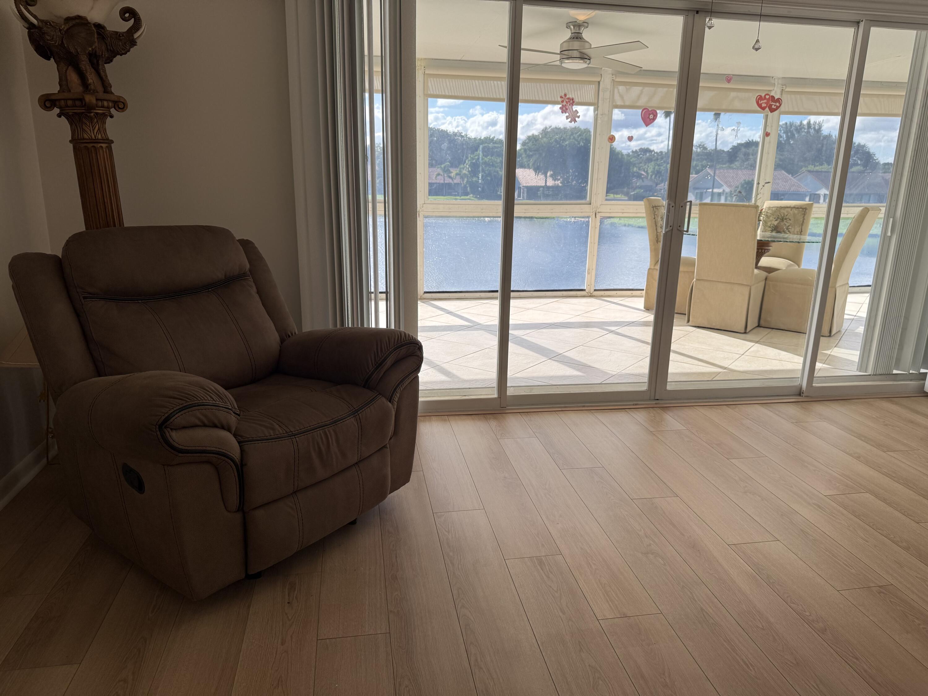 1720 Northwest 20th Avenue, Unit 204 Delray Beach, FL 33445 - Photo 16 of 30 a living room with furniture and a floor to ceiling window