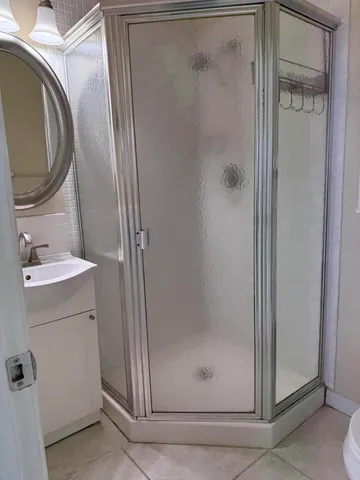 a bathroom with a shower a mirror and a sink
