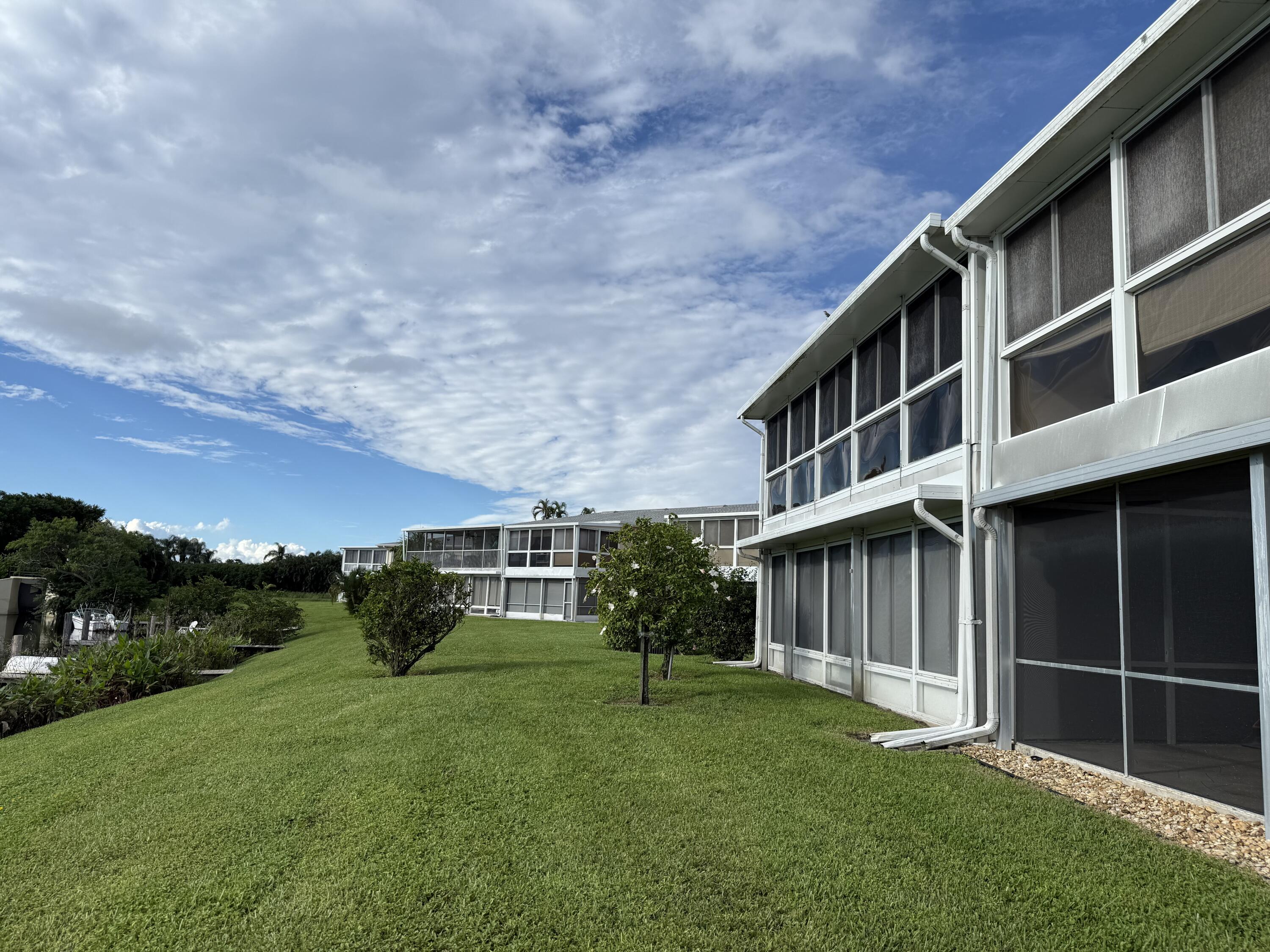 1720 Northwest 20th Avenue, Unit 204 Delray Beach, FL 33445 - Photo 3 of 30 a backyard of a house with plants and wooden fence