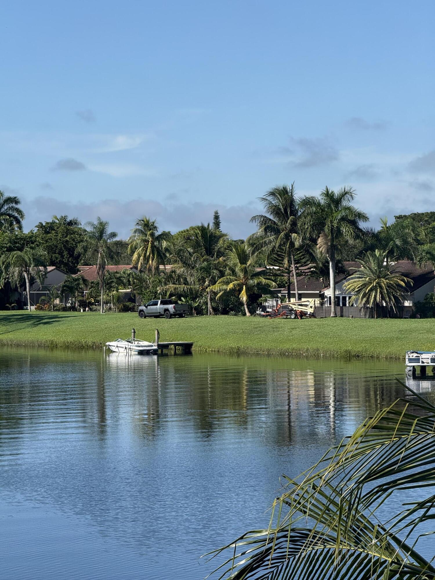 1720 Northwest 20th Avenue, Unit 204 Delray Beach, FL 33445 - Photo 7 of 30 a view of a lake with a house in the background