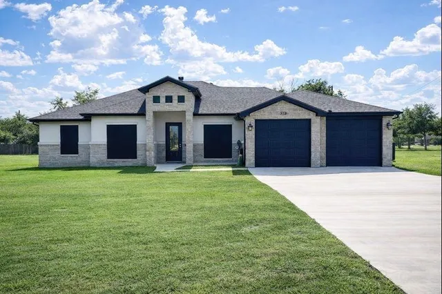 a front view of a house with a garden and yard