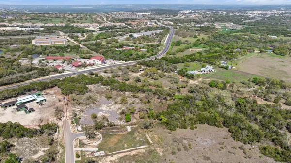 an aerial view of residential house with parking and trees